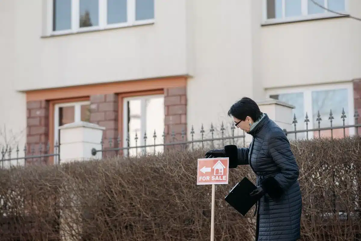 A smartphone screen displaying a real estate listing with price tag, QR code visible, suspect link in messaging app.