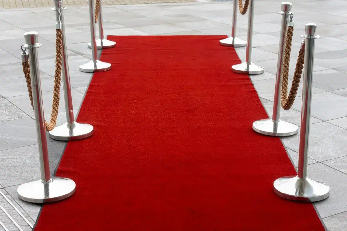 Alfombra roja de premiere cinematográfica con decoración elegante y multitud de asistentes