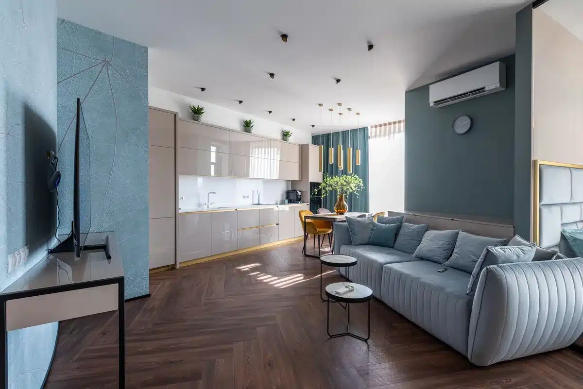 A compact air purifier with a distinctive star-shaped nozzle on top, placed in a minimalist living room corner, emitting a subtle air jet, soft morning light filtering through windows