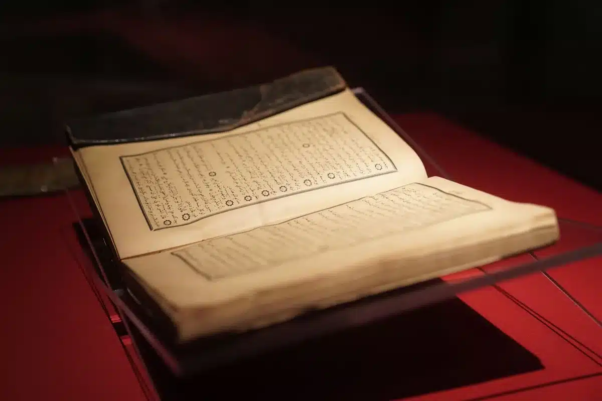 Páginas antiguas de un manuscrito iluminadas con luz celestial y sombras cósmicas