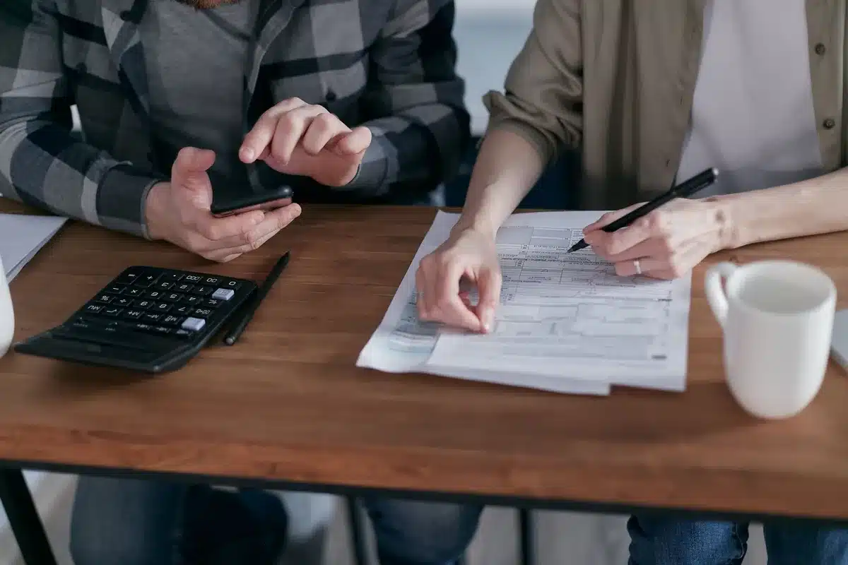 Persona siendo atendida en una oficina de servicios fiscales con documentos y computadora