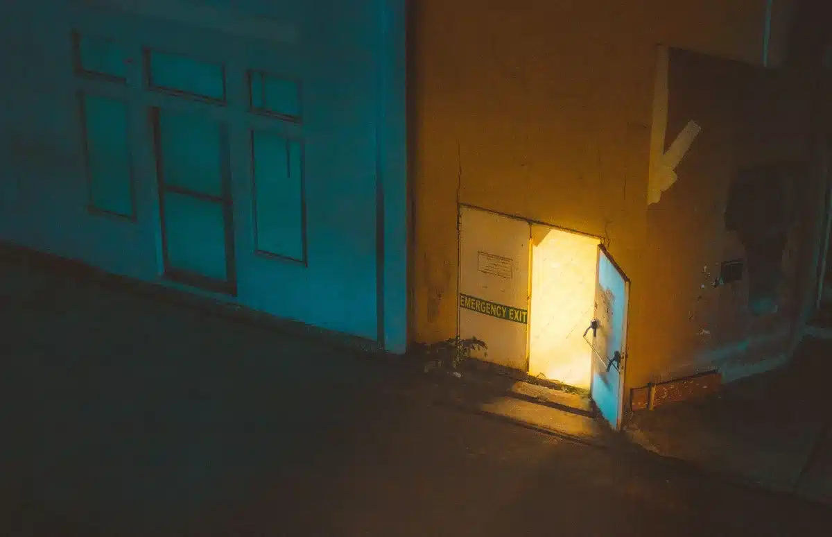 Puerta abierta a un plano oscuro y sobrenatural con luz etérea filtrándose