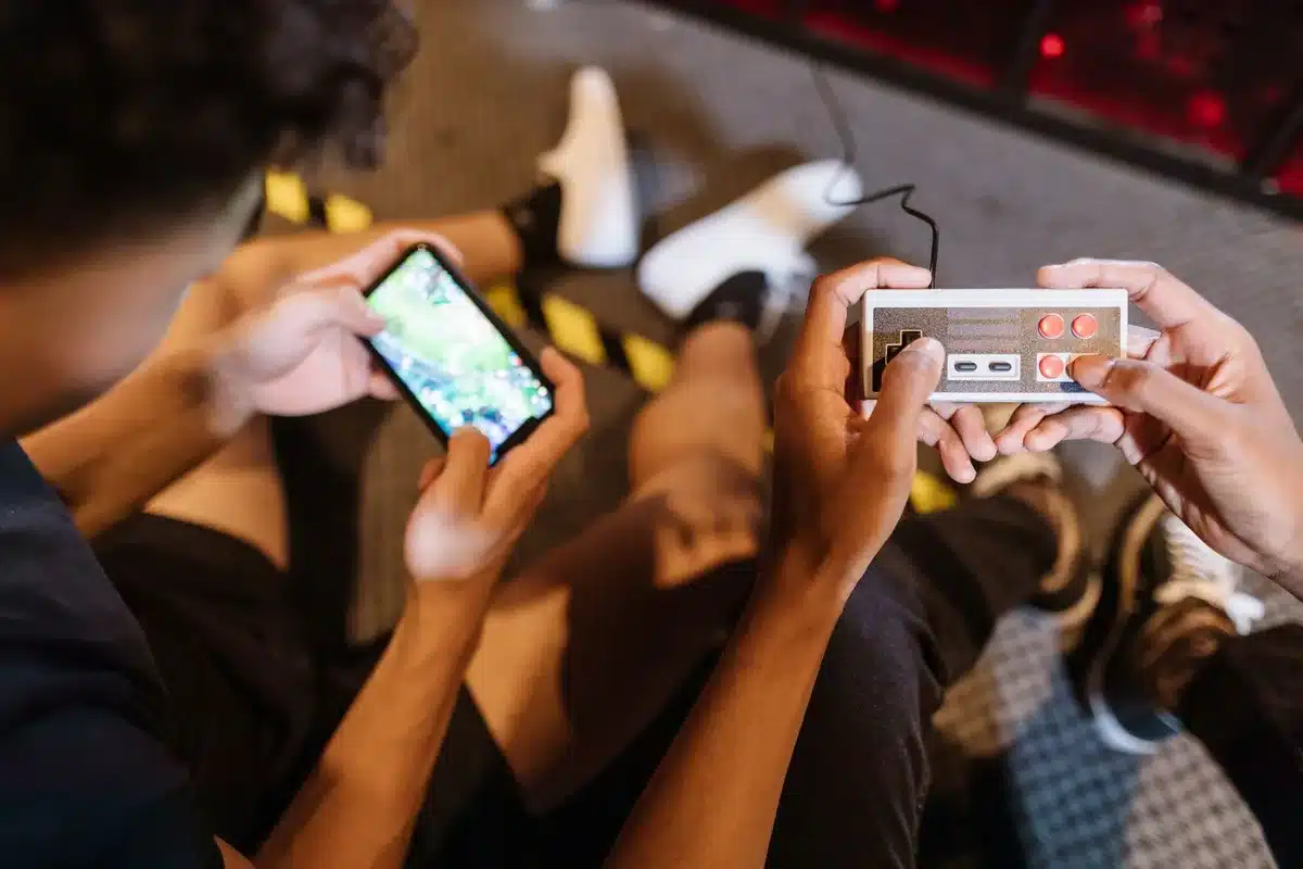 Jugador sosteniendo un teléfono con mando retro, jugando a un juego clásico de emulador
