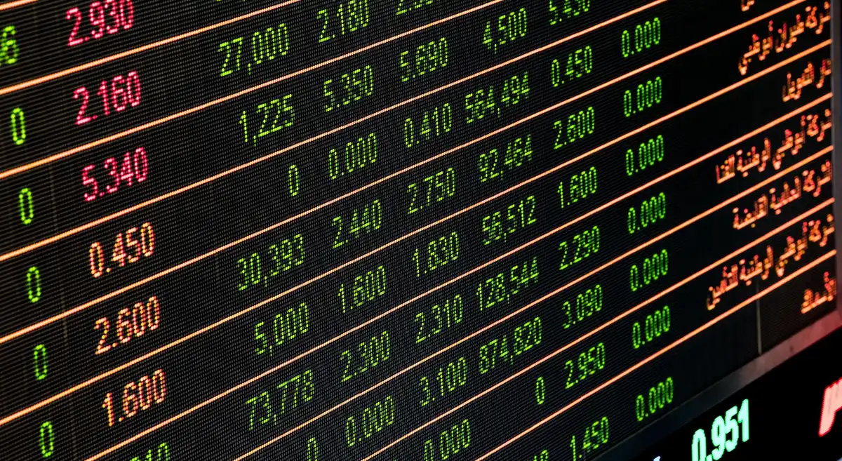 Pantallas de mercados financieros mostrando volatilidad y cambios en índices bursátiles