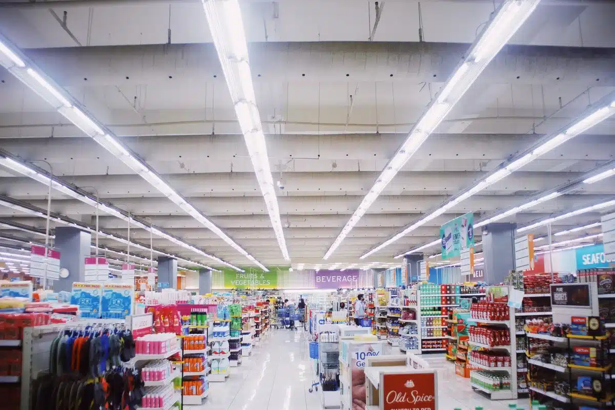 Shelves in a Mexican supermarket displaying both European and American cheese varieties side by side, showing the market competition