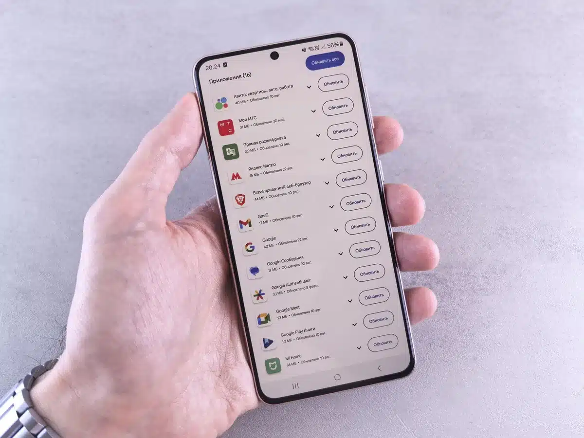 Hands holding a Samsung Galaxy phone showing the calendar app with multiple synchronized calendar sources visible, color-coded events, modern interface