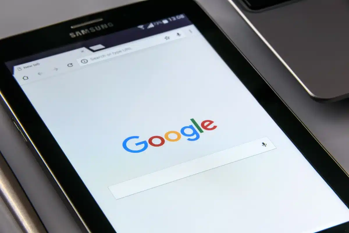 Array of Samsung Galaxy devices displayed on a white surface—smartphone, tablet with stylus, earbuds, and smartwatch—arranged in a flat lay composition with soft shadows