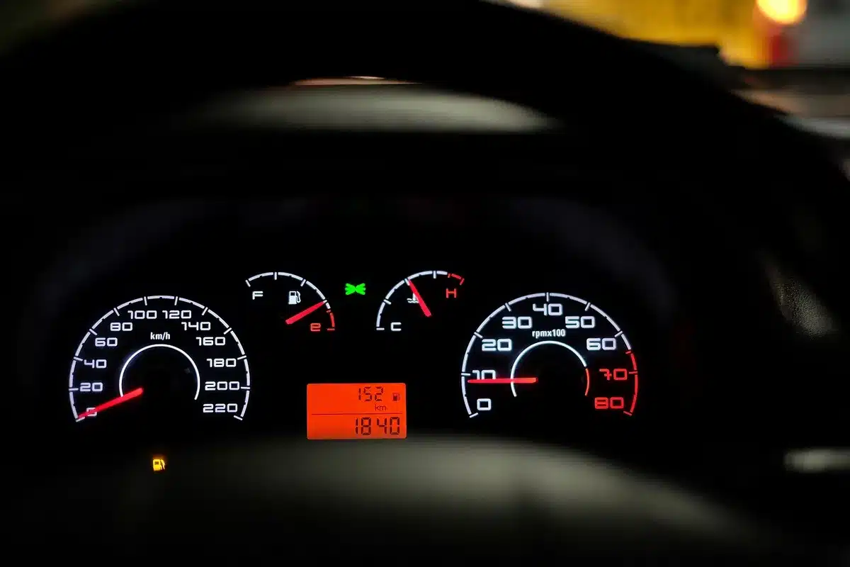 Close-up of refrigerator control panel with digital display, temperature settings visible, interior LED lighting illuminating fresh vegetables and beverages