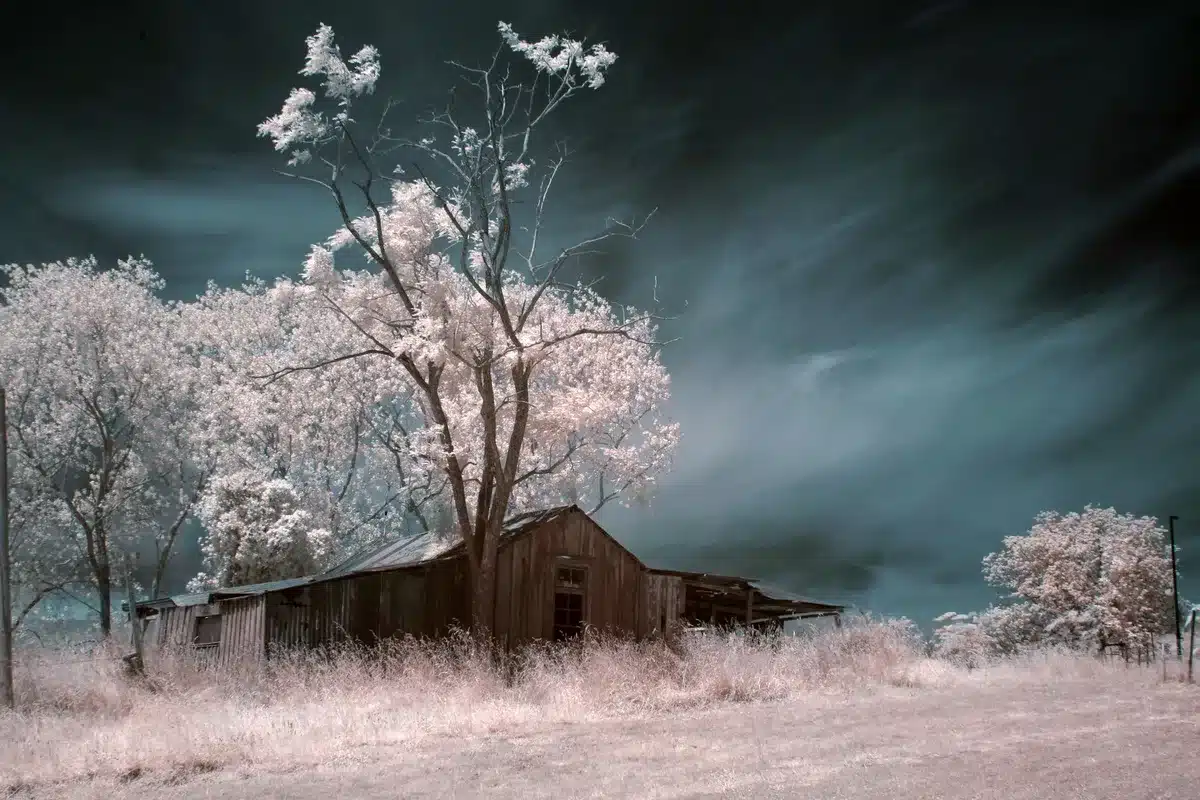 Casa rural aislada en Texas al atardecer con vehículo varado en el camino