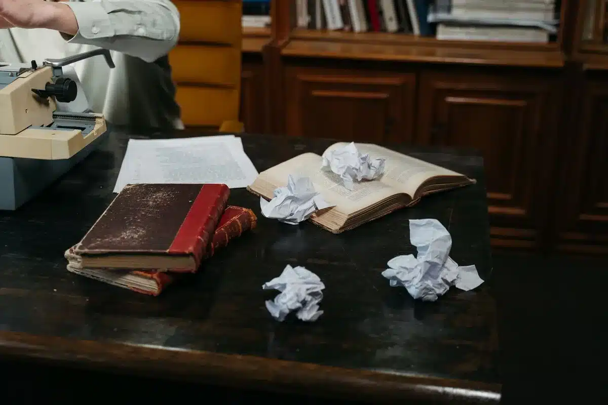 Escritorio de trabajo con páginas de cómics y manuscritos de guiones apilados