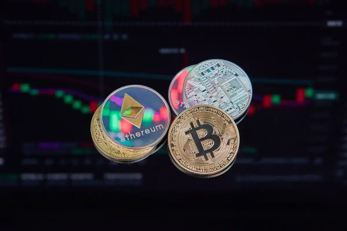 Manos anónimas trasladando monedas digitales a una bóveda segura junto con documentos financieros tradicionales