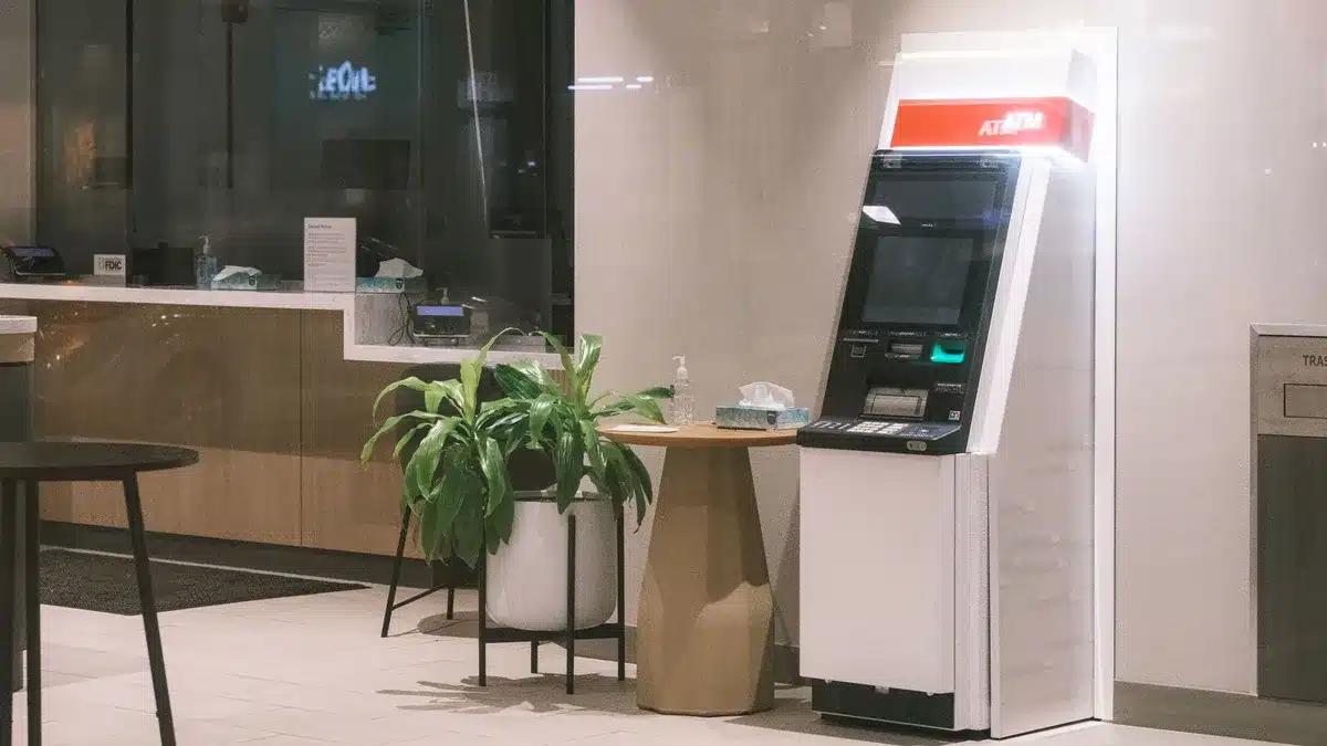 Empty bank branch counter with an anonymous pamphlet stack and a single card on the counter, no logos