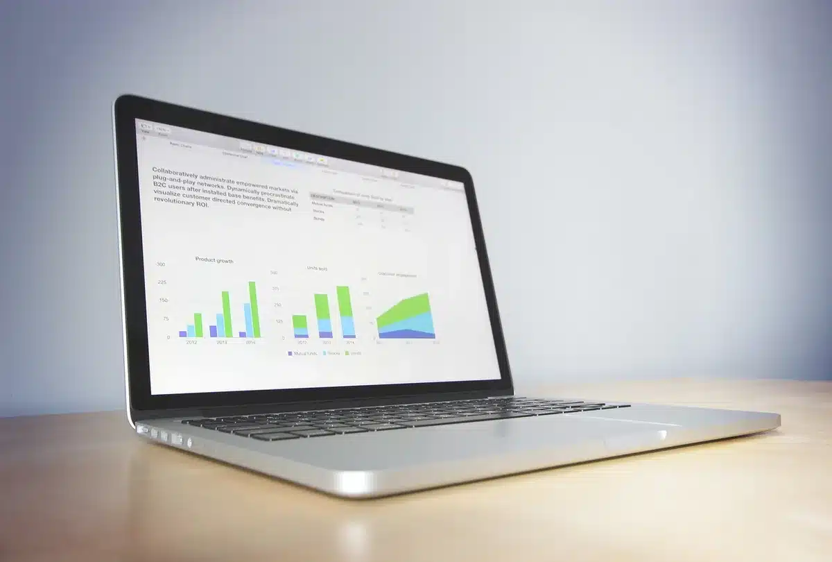 Analista revisando gráficos de datos económicos e inflación en un escritorio con reportes de tasas de interés