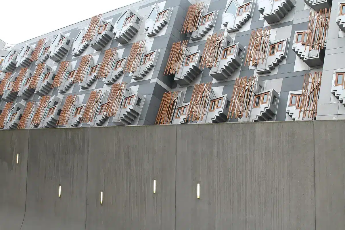 Minimalist white concrete facade with staggered terraces and narrow windows, no people