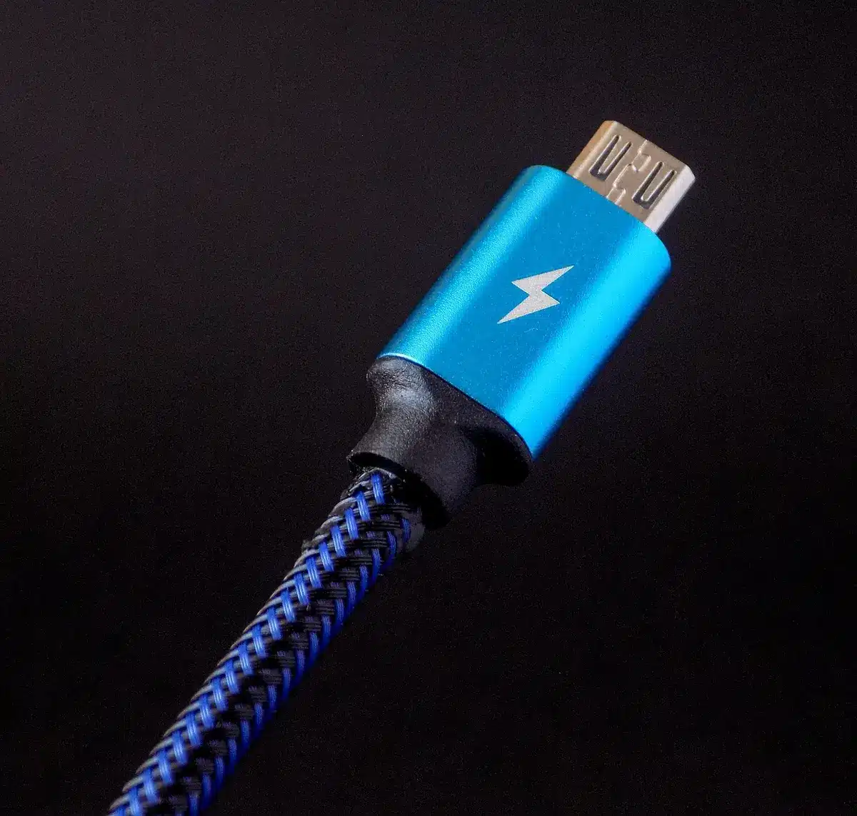 Close-up of an unbranded USB-C to HDMI adapter plugged into a generic smartphone on a table, HDMI cable leading off-frame