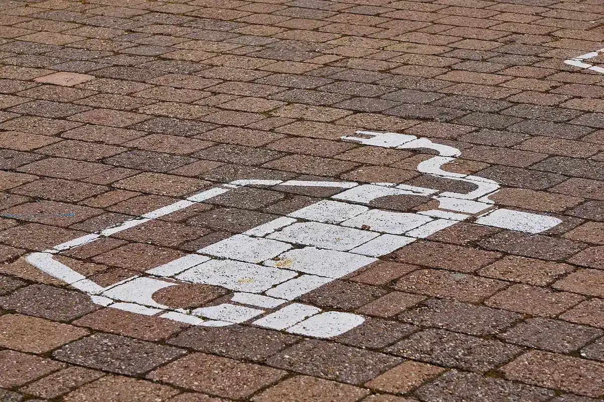 Multiple golden Cybercabs lined up in a charging station at dusk, induction charging cables glowing softly, urban backdrop, fleet operations