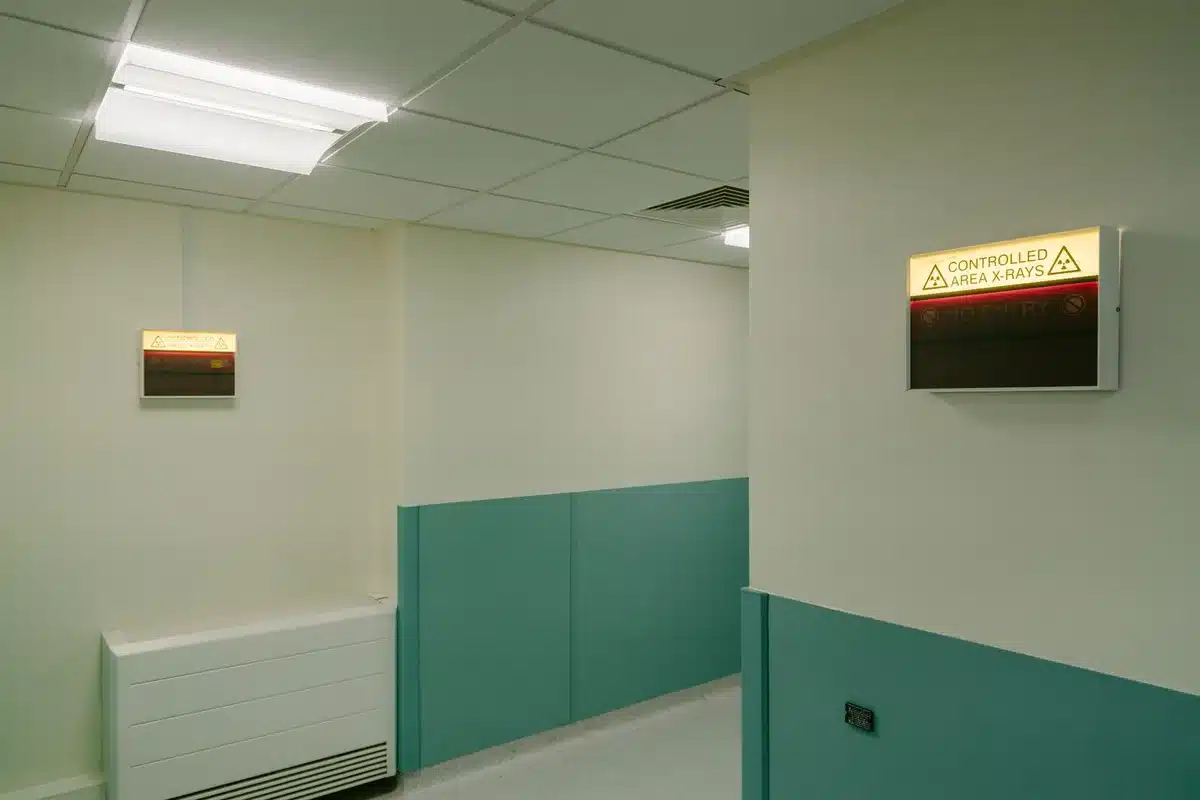 Empty VIP hospital corridor with a guarded entrance, no people visible, soft daylight