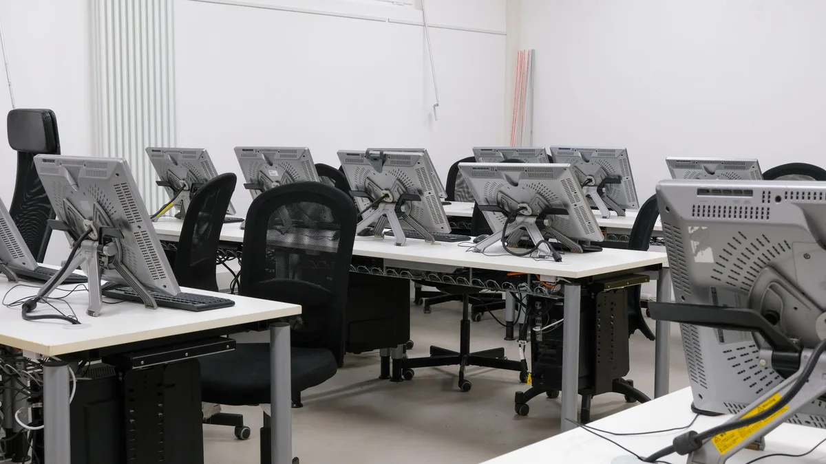 empty classroom with stacked chairs and a closed door, a Mexican flag out of focus in the background