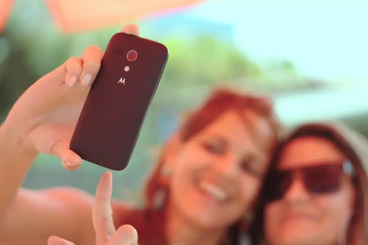 A close-up of a smartphone's camera module with the triple lens configuration clearly visible, mounted on a minimalist background with soft lighting that highlights the optical engineering and glass surfaces