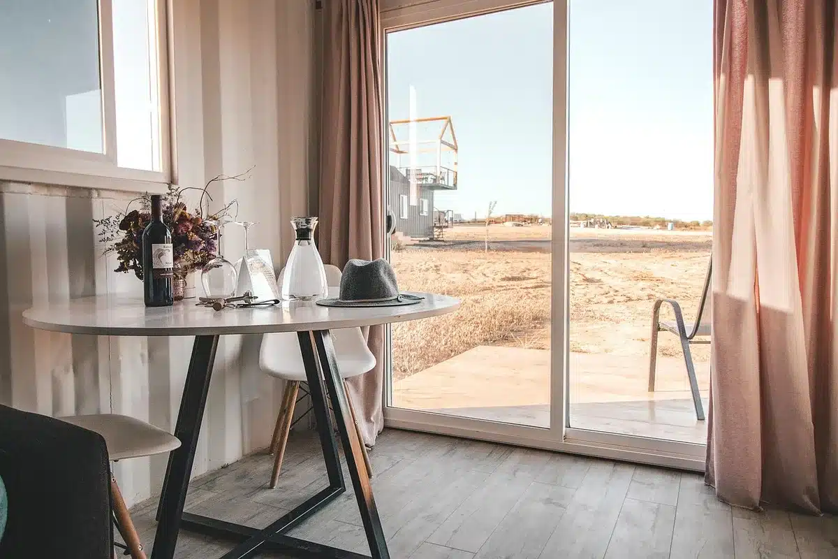 Habitación de hotel con botella y luz tenue, evocando noches solitarias