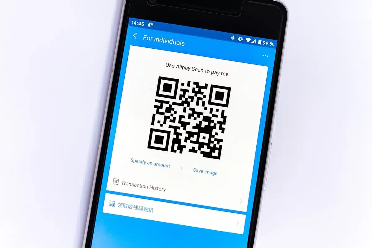 close-up of an anonymous hand pausing over a mobile banking app screen, a translucent warning icon overlaid subtly