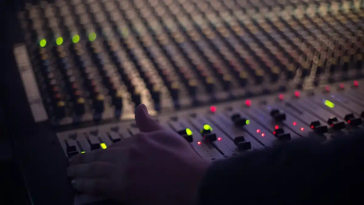 A glowing microphone stand in a darkened studio, surrounded by abstract sound waves and musical notes materializing in soft blue light, evoking AI-driven creativity and composition in progress.