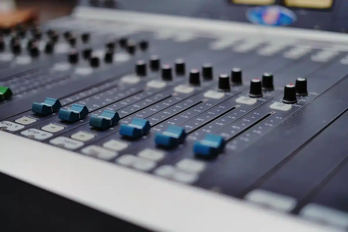 A laptop screen displaying waveforms and musical parameters, hands poised over the keyboard in a creative workspace, soft ambient lighting reflecting off the device, showing the moment before generating a new composition.