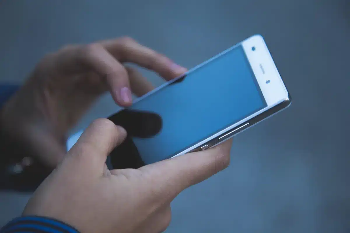 Close-up of a smartphone hinge mechanism with metallic liquid metal details, showing durability design elements