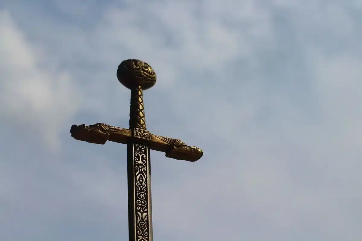 Close-up of an unbranded glowing sword and a simple blocky chest on a mossy stone altar in a stylized dungeon, no logos, no characters' faces visible