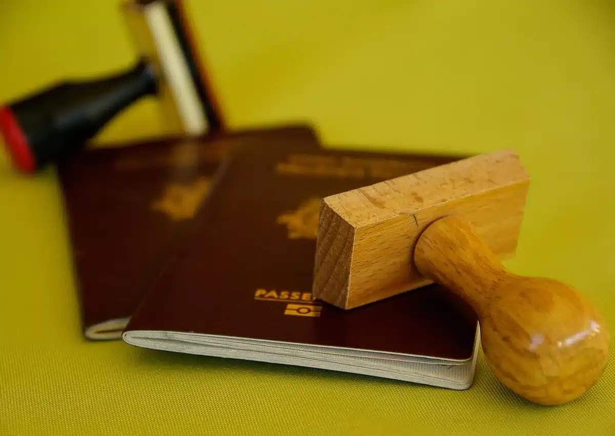 Maletín, pasaporte y cuaderno abierto sobre mesa de café iluminada junto a una ventana