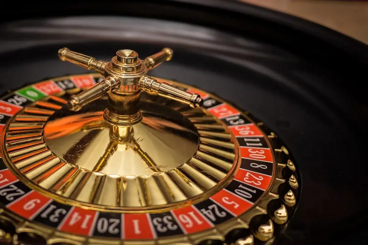 Mesa de ruleta con fichas y silueta de jugador de fondo