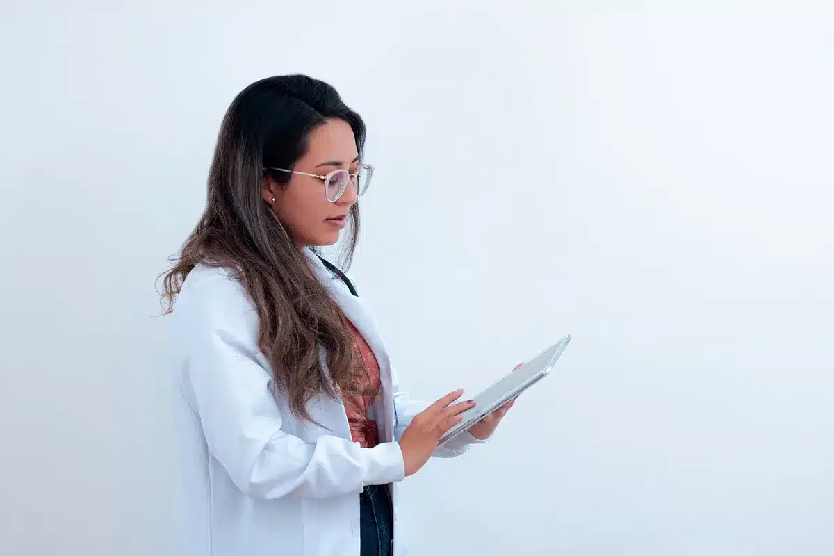 Ficha médica y manos del médico documentando efectos adversos