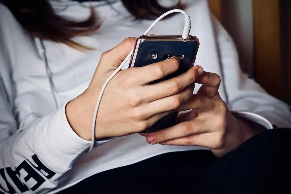 Anonymous hands holding smartphone showing a generic ride-hailing app interface, blurred map in background, no logos