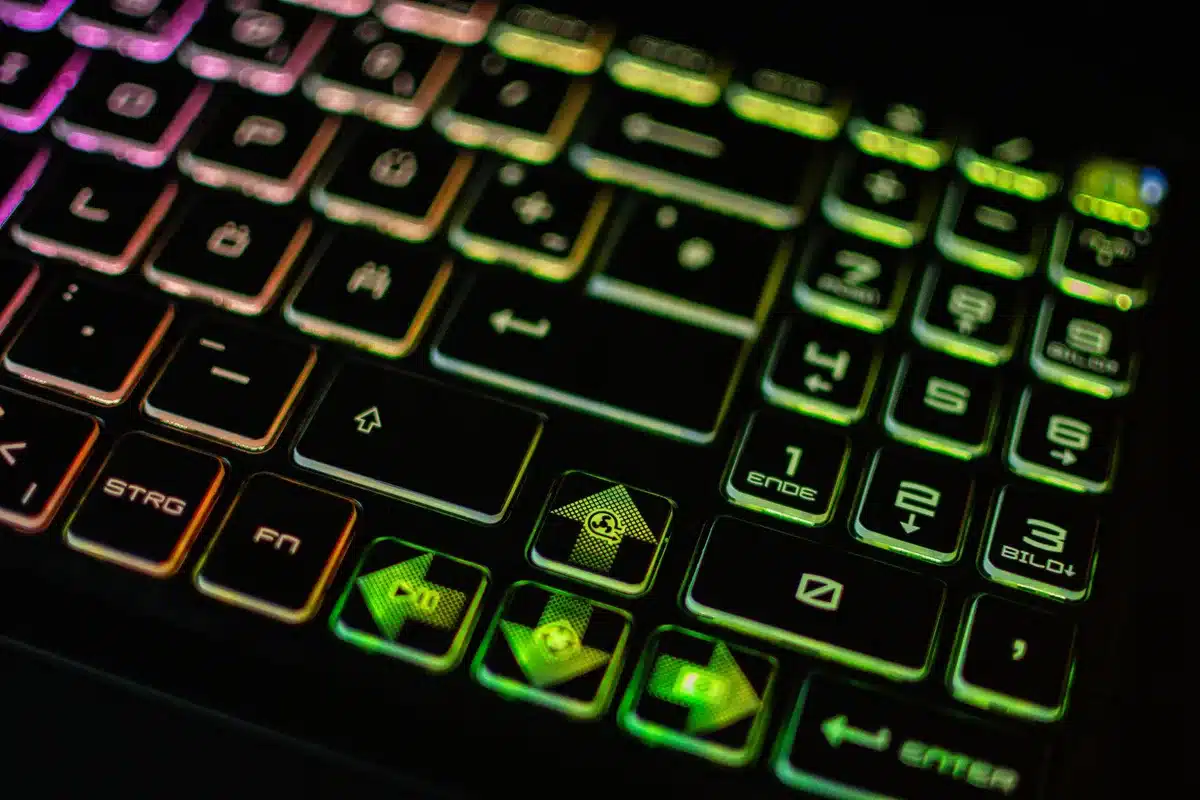Slim gaming laptop on a desk with an open browser showing a shopping page, anonymous room background