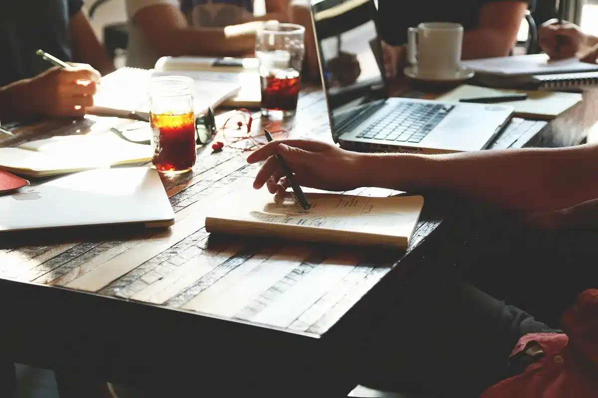 Manos anónimas revisando un informe económico con calculadora en una mesa de oficina