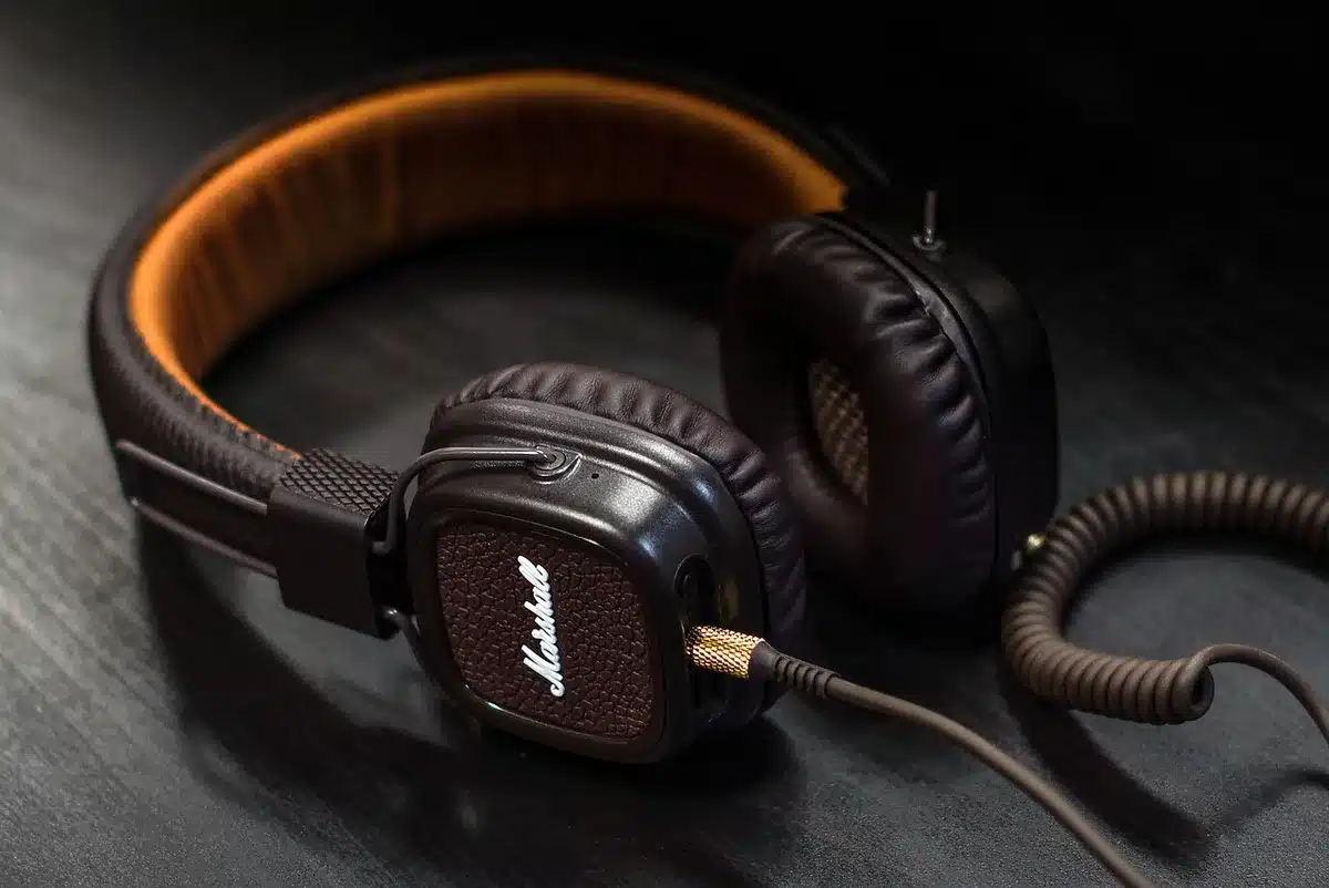 Close-up of a coiled USB cable and controller buttons on a wooden desk, controller anonymous and unbranded, soft studio lighting