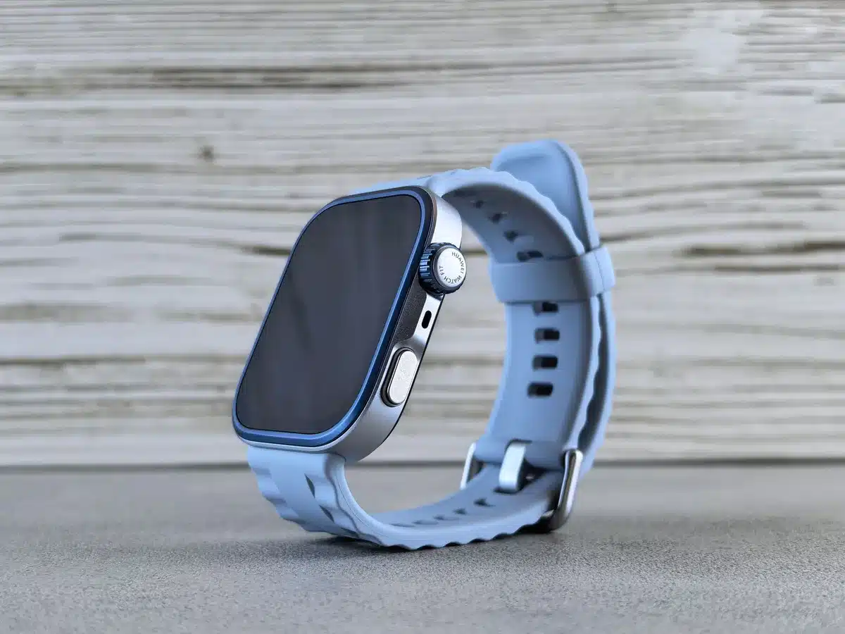 A close-up of an unbranded soft silicone wristband on a neutral surface, dual tiny microphones visible, no logos or text