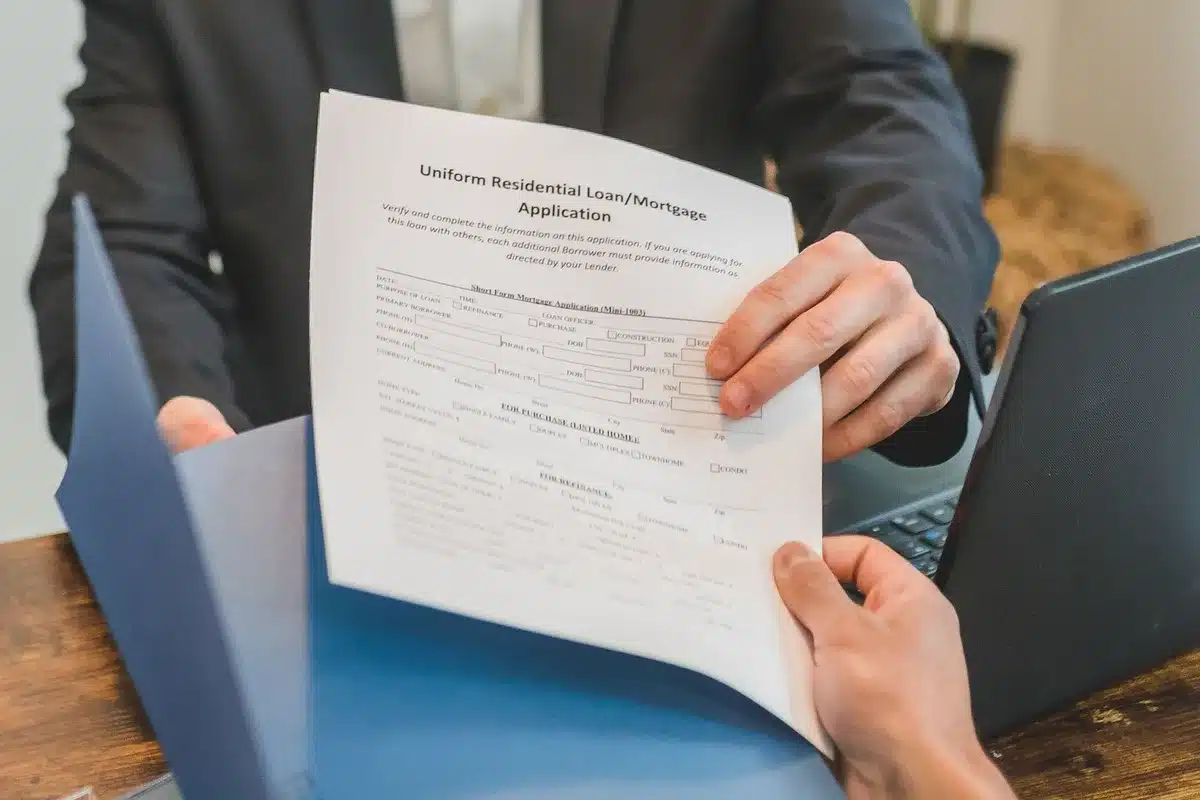 close-up of anonymous hands holding a bank statement and a smartphone showing a blurred transaction list