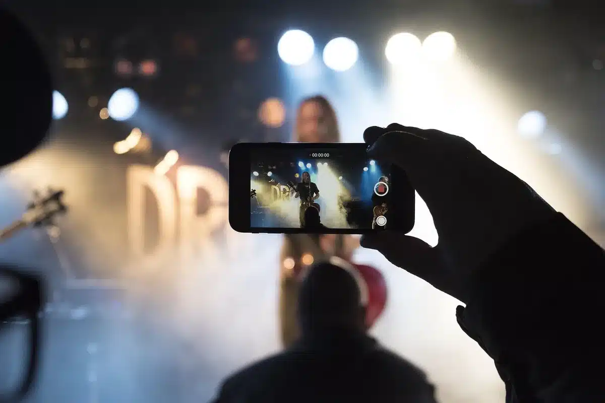 anonymous hands holding unbranded phone taking a photo of city lights