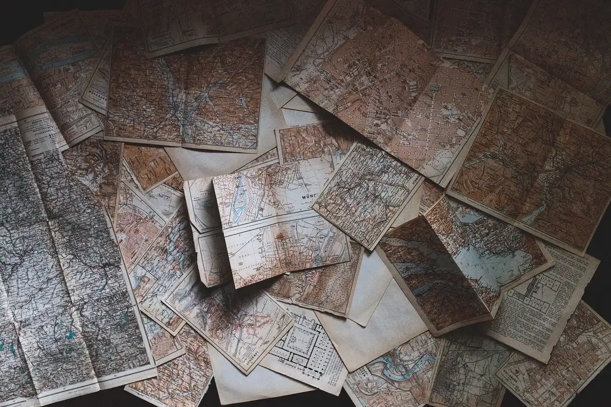Dim interior of a candlelit study with an open period map, a quill, and a folded letter hinting at conspiracy