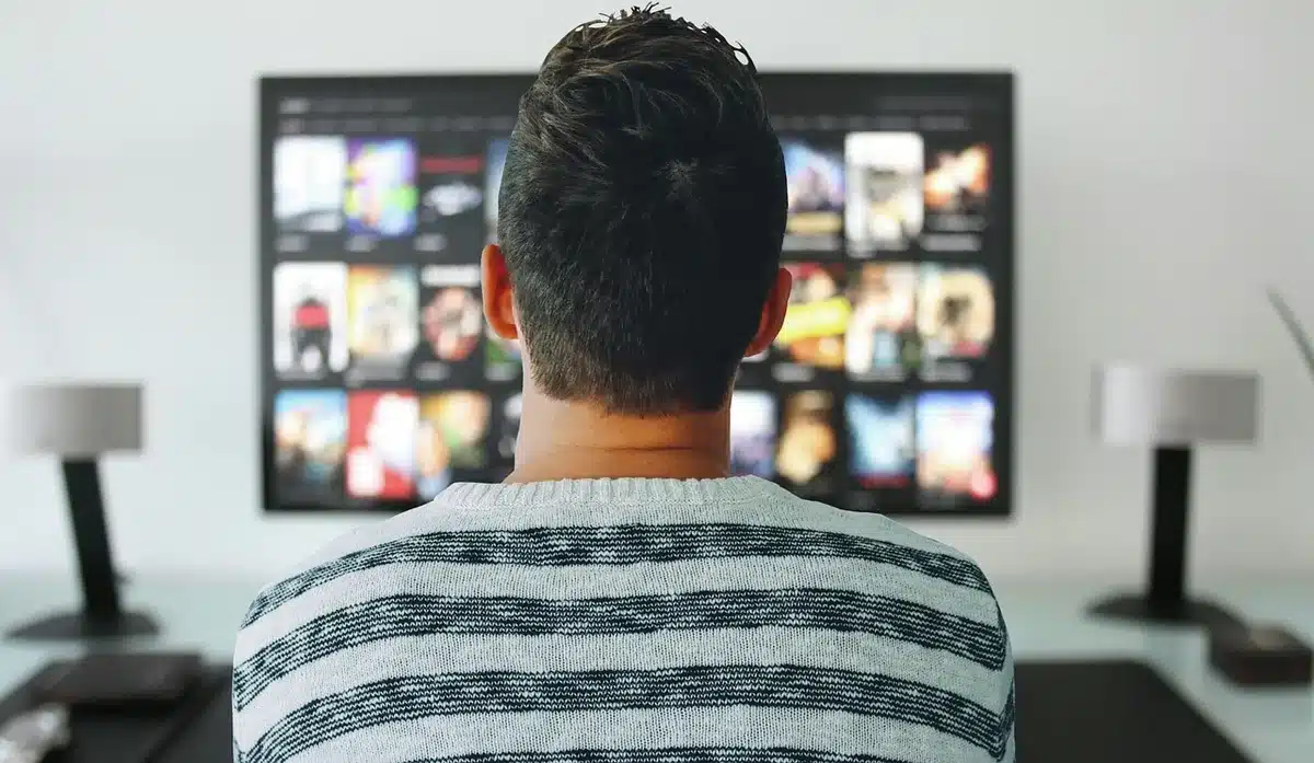 Empty home-screen TV displaying a generic streaming app interface with Peacemaker-style poster placeholder on-screen, no logos or real faces