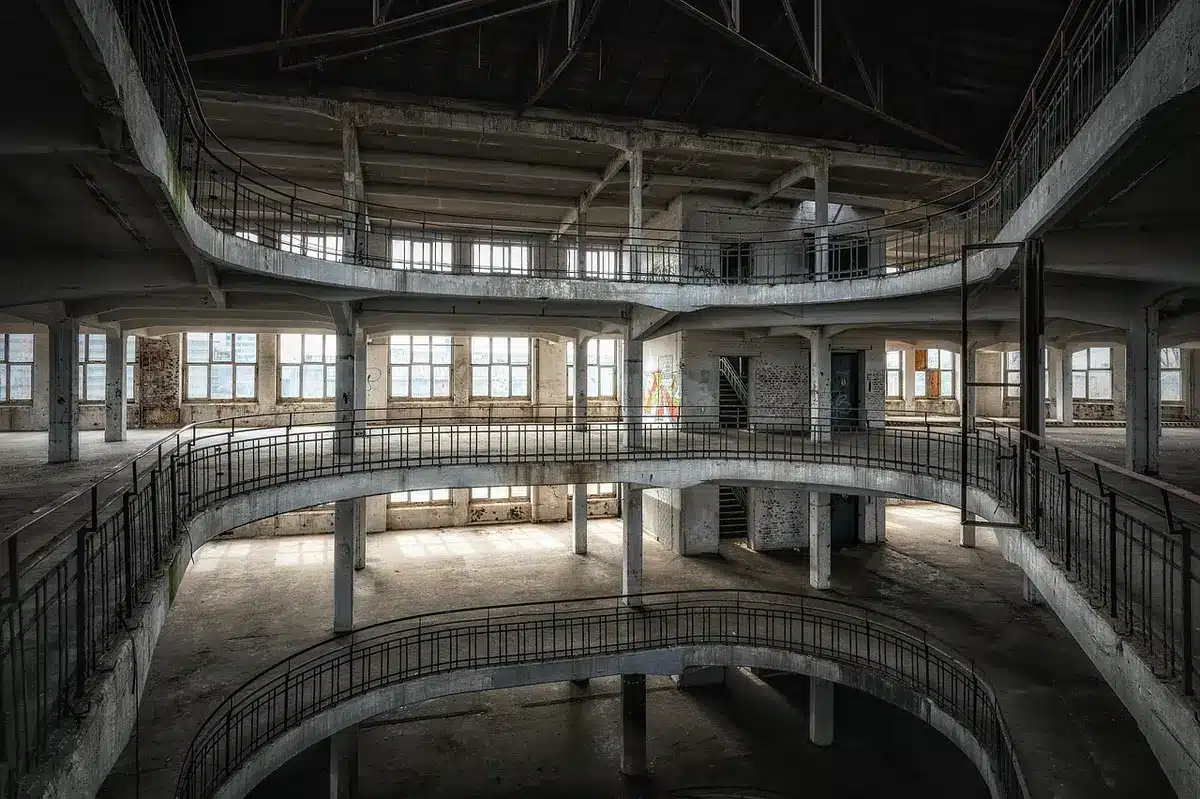 Interior de fábrica con maquinaria vacía representando caída de la producción