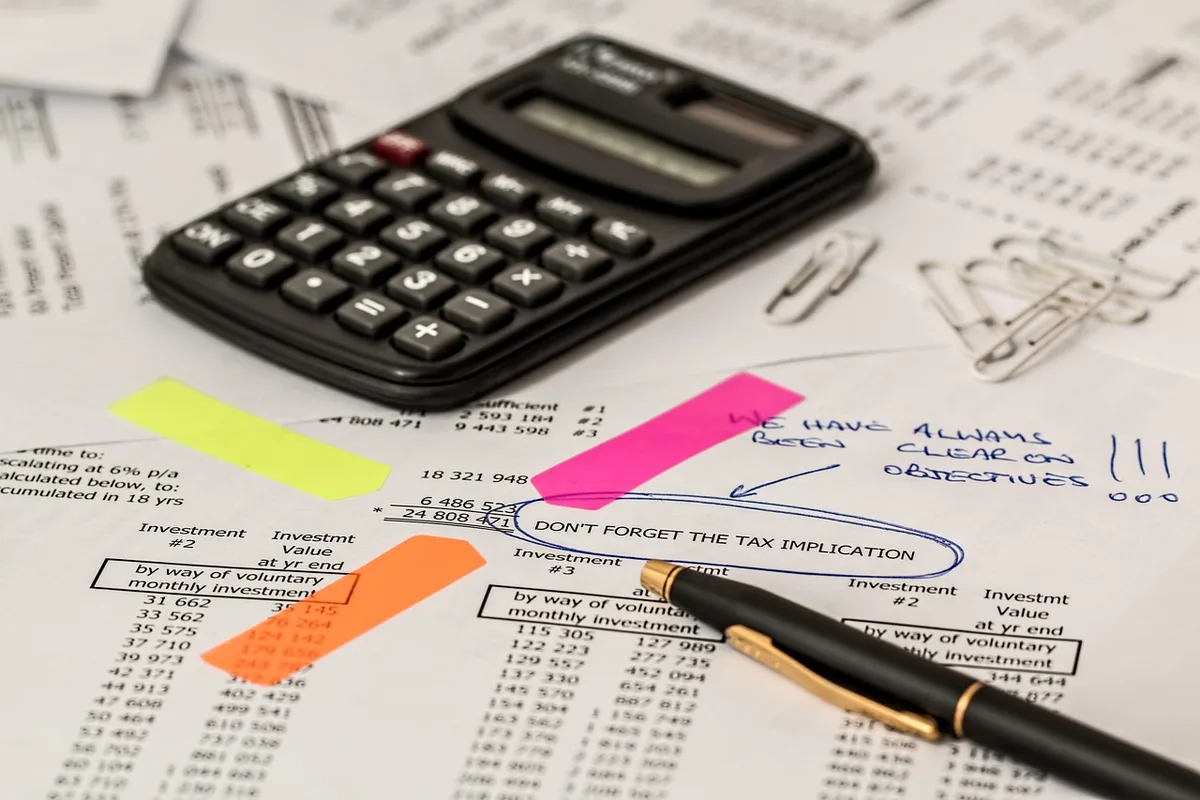Mesa de juntas con carpetas, comprobantes y calculadora representando revisión fiscal