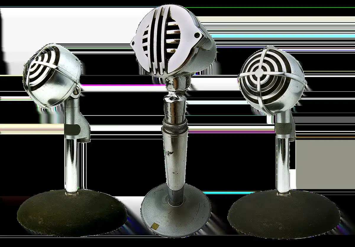 A single vintage microphone on an empty studio stand under one hard spotlight, the room behind it sinking into shadow, dust motes visible in the beam, a coiled cable trailing off into darkness
