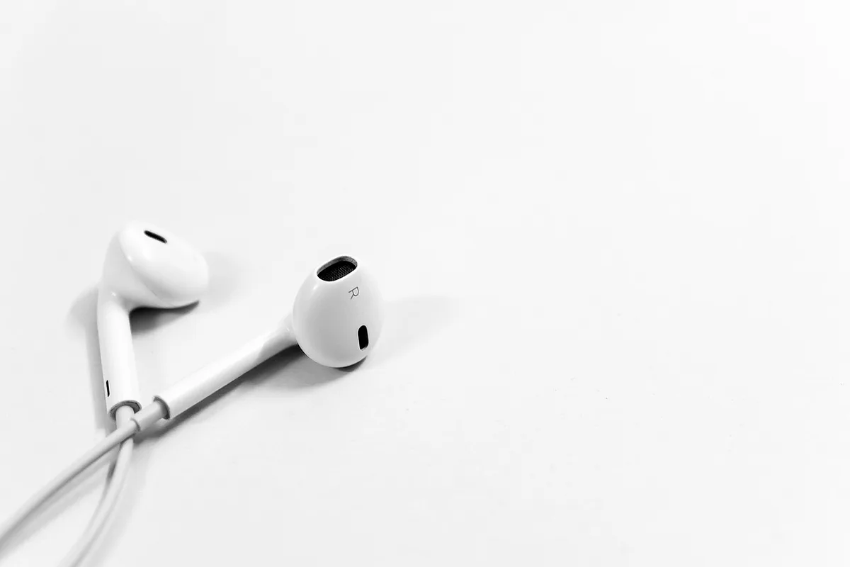 Empty premium headphone display on a pedestal, single spotlight, no branding