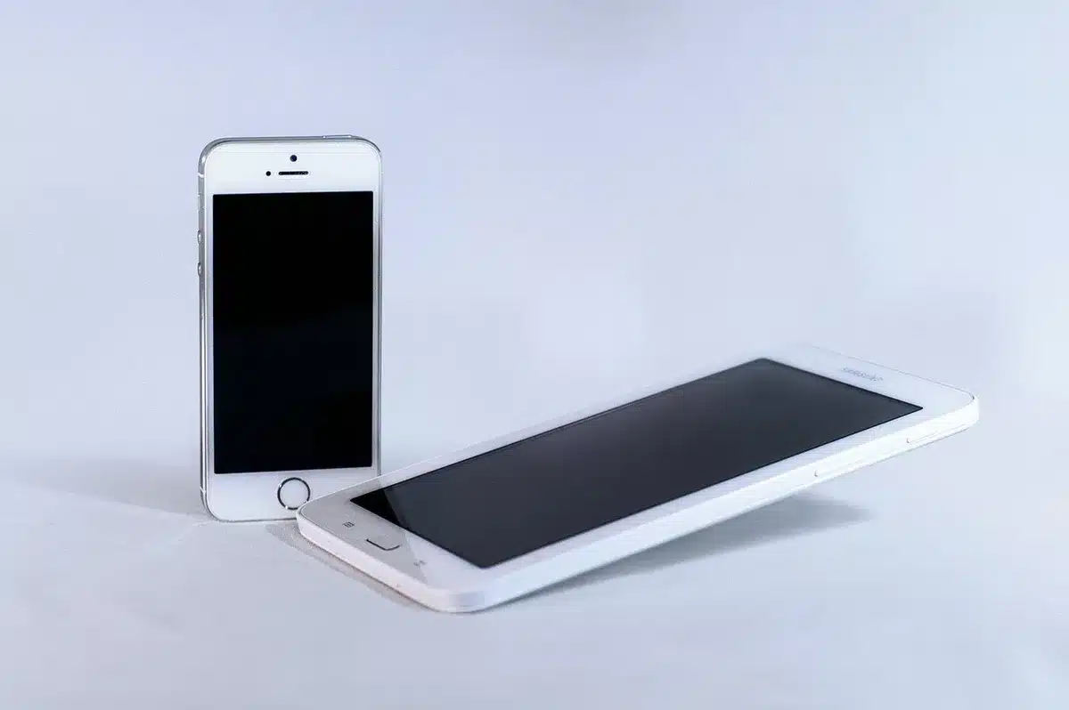 OPPO-like smartphone on a neutral table next to an unbranded camera lens, soft indoor light, no logos
