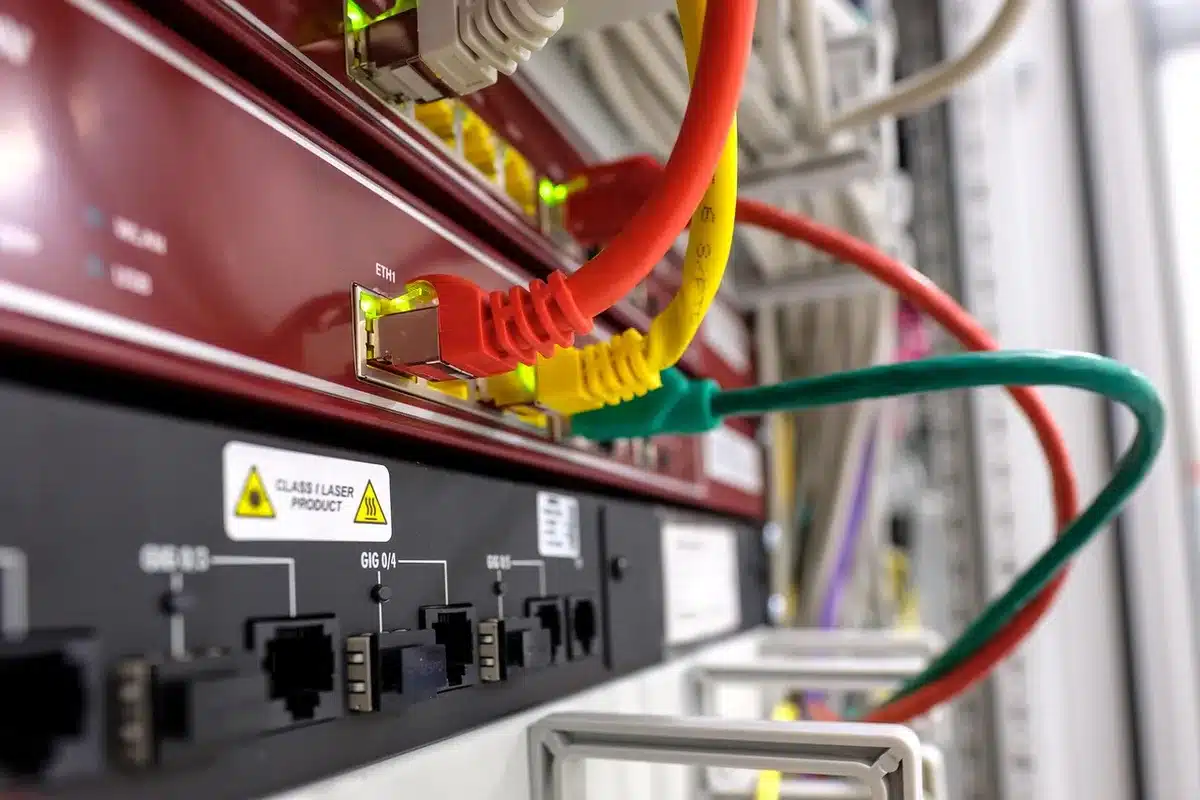 Empty server rack with blinking network lights and a lone maintenance ladder nearby, suggestive of urgent patching