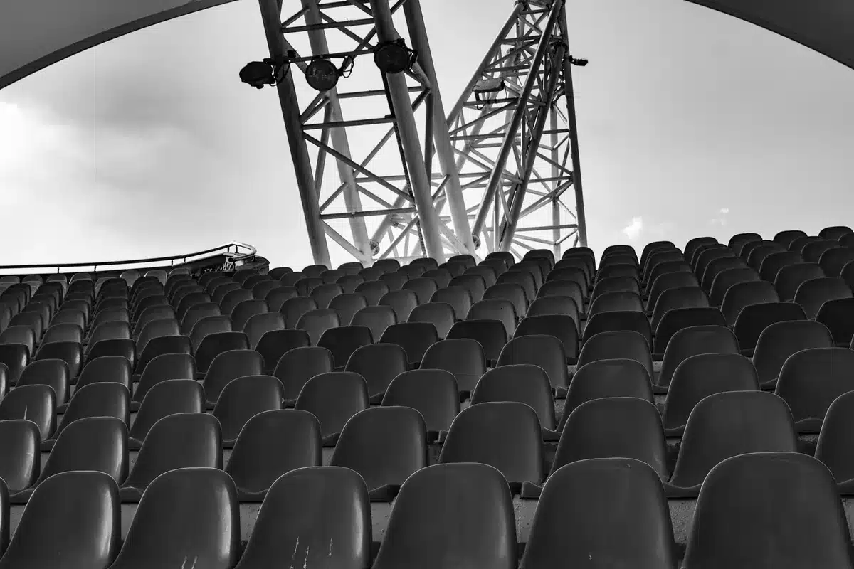 empty stadium interior at dusk, seats and large unbranded scoreboard visible