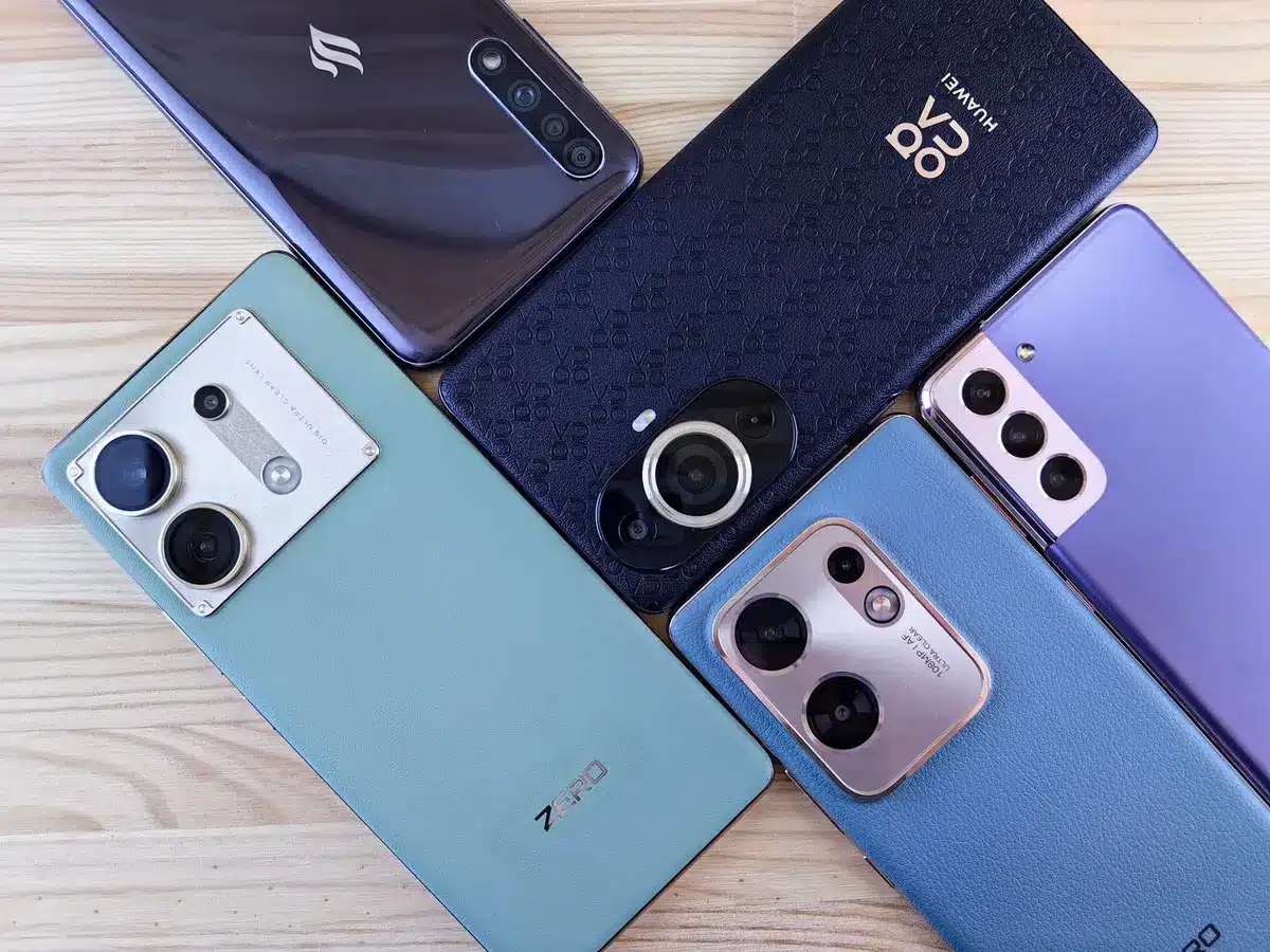 A clean still life of three anonymous high-end smartphones arranged on a neutral table, no logos visible, soft reflections on screens