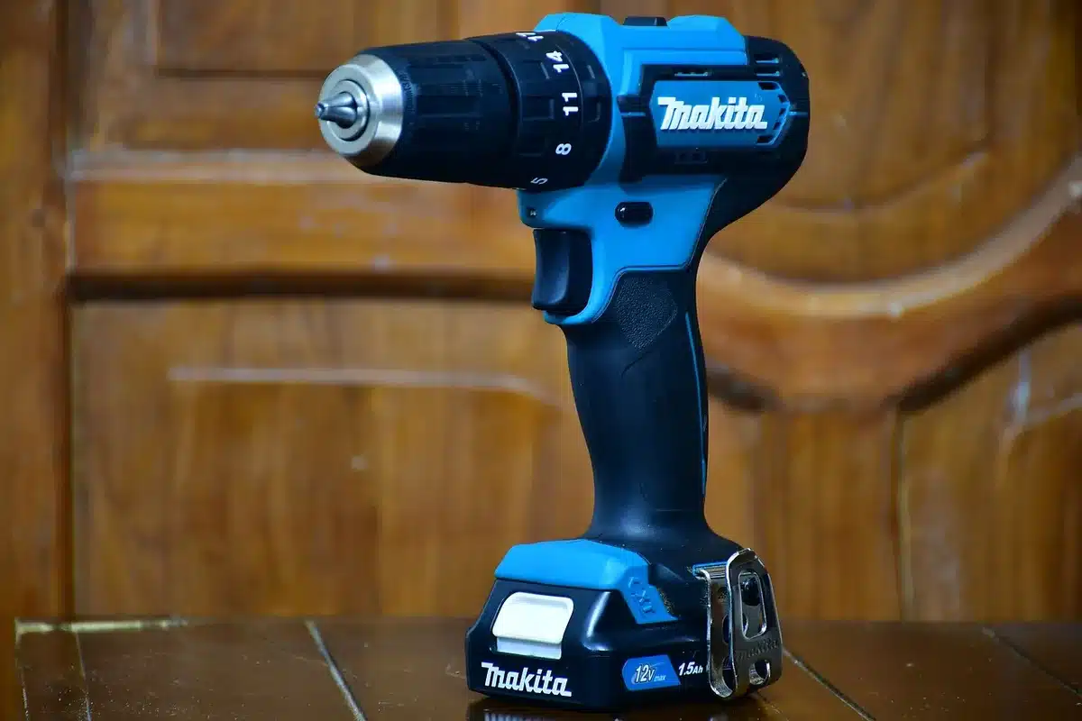 close-up of anonymous power drill on a workbench with metal shavings and a measuring tape nearby